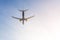 Big passenger airlplane flying against clear blue sky during sunset. Landing or take off. Bottom view. Copyspace for text. Summer