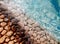 Big pebbles and stones under blue transparent water on the beach