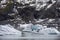 Big pieces of freshwater ice in the frozen lake surrounded by rocky mountains