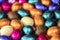 Big pile of colorful wrapped chocolate easter eggs, shiny festive Easter concept, Happy easter close-up candy sweets