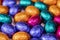 Big pile of colorful wrapped chocolate easter eggs, shiny festive Easter concept, Happy easter close-up candy sweets