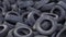 Big pile of used black car wheels on the empty territory