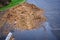 Big pile of wood chips in an asphalt parking lot, ready to be put to use