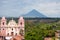 Big Pink Church Standing in front of a Mountain