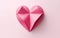 Big pink origami heart isolated on pink background. Adorable paper object.