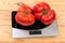 Big pink tomatoes on digital kitchen scale on rustic table
