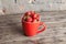 Big red cup filled with succulent juicy fresh ripe red strawberries on an old wooden textured table top with brick background