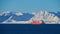 Big red painted LNG carrier vessel lying at anchor in the arctic ocean in front of SÃ¸rÃ¸ya island in winter time.