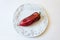 Big red ripe Capsicum annuum Cubanelle pepper, Cuban pepper, Italian frying pepper, on bright white plate, food