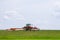 Big red tractor with two mowers mows the grass for silage