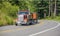 Big rig Brown tipper truck with two dump trailers running on the turning road in forest