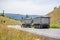 Big rig Brown tipper truck with two dump trailers running on the turning road in forest