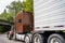 Big rig classic brown semi truck tractor transporting commercial cargo in refrigerator semi trailer running for delivery on the