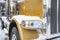 Big rig classic gold semi truck with chrome accessories standing on the winter parking lot with snow and ice