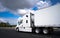 Big rig long haul semi truck transporting goods in semi trailer