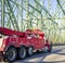 Big rig powerful towing semi truck for tow large transportation driving on truss arched bridge