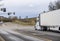 Big rig semi truck with reefer semi trailer transporting frozen food on the city road