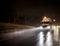 Big rig white semi truck transporting cargo in semitrailer driving on the night wet road with heavy rain and water dust