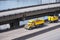 Big rig yellow tipper semi truck with dump trailer running on overpass intersection road along the river