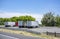 Big rigs semi trucks with loaded dry van semi trailer standing together on the rest area parking lot next to highway