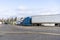 Big rigs semi trucks staing in row on wide truck stop parkink lot