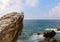 Big rocks in the middle of the sea or ocean with great blue raging water waves breaking on a stone.