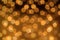 Big round Bokeh in golden yellow on dark brown background. Abstract Blurred circles