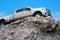 Big rugged pickup truck driving on a rocky cliff ledge