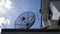 Big Satellite Dish, small red Satellite Dish and Antenna TV on the roof of house against with blue sky and white clouds
