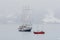 Big ship and small yacht in Arctic fjord