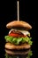 Big single cheeseburger isolated on black background