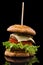 Big single cheeseburger isolated on black background