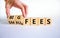 Big or small fees symbol. Businessman turns a wooden cube and changes words `small fees` to `big fees`. Beautiful white table,