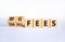 Big or small fees symbol. Turned wooden cubes and changed words `small fees` to `big fees`. Beautiful white table, white