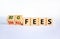 Big or small fees symbol. Turned wooden cubes and changed words `small fees` to `big fees`. Beautiful white table, white