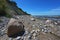 Big and small stones on the beach in front of the steep coast at the Baltic Sea, beautiful landscape for hiking, blue sky with