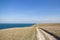 Big stones calm sea, clear sky with clouds skyline and road