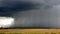 Big storm with rain coming down from the clouds - black clouds and rain over the field - storm landscape - rainy season