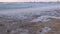 Big stormy waves in the sea. Beautiful seascape with pier, sandy beach and coastal town on background at sunset.