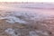 Big stormy waves in the sea. Beautiful seascape with pier, sandy beach at sunset.