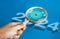 Big target dart icon inside magnifying glass lens hold by hand while looking at 2024 year number on blue background.