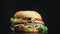 Big and tasty burger is rotating on the plate. Isolated footage