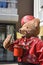 Big teddy bear with red hat and leather jacket blows soap bubbles in the air