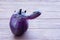 Big ugly purple eggplant on a wooden background. Organic vegetable Solanum melongena. Conscious eating concept