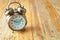 Big vintage alarm clock with bells, painted antique wooden background
