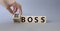 Big vs small boss symbol. Businessman hand turnes wooden cubes and changes words Small boss to Big boss. Beautiful grey background