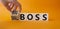 Big vs small boss symbol. Businessman hand turnes wooden cubes and changes words Small boss to Big boss. Beautiful orange