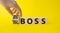Big vs small boss symbol. Businessman hand turnes wooden cubes and changes words Small boss to Big boss. Beautiful yellow