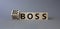 Big vs small boss symbol. Turned wooden cubes with words Small boss and Big boss. Beautiful grey background. Business concept.