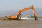 Big water excavator dredging sediment mud from river